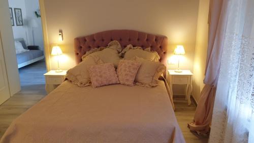 a bedroom with a bed with pillows and two lamps at CasAlbina in Mezzana