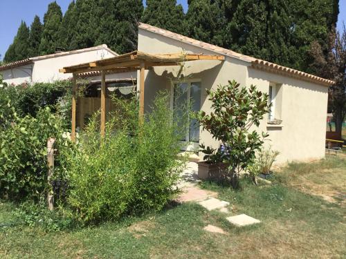 a small house in a yard with bushes at Le jardin du Castillon in Paradou
