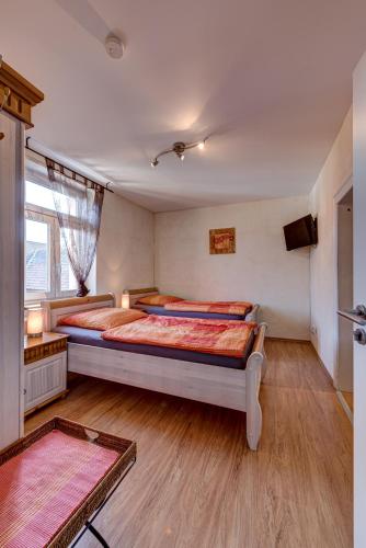 a bedroom with two beds and a television in it at Jakobshof in Freckenfeld