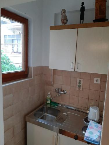 eine kleine Küche mit einem Waschbecken und einem Fenster in der Unterkunft City centre in Stari Grad
