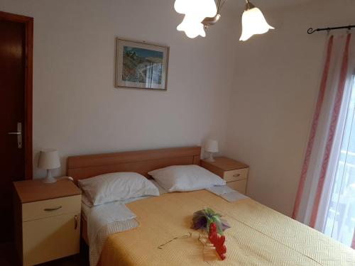ein Schlafzimmer mit einem Bett mit einer Blume darauf in der Unterkunft City centre in Stari Grad
