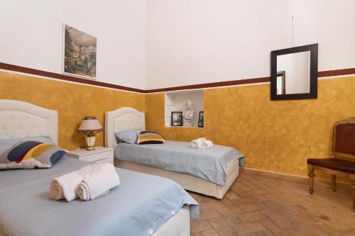 een slaapkamer met 2 bedden en een spiegel bij appartment 53 piazza Navona in Rome
