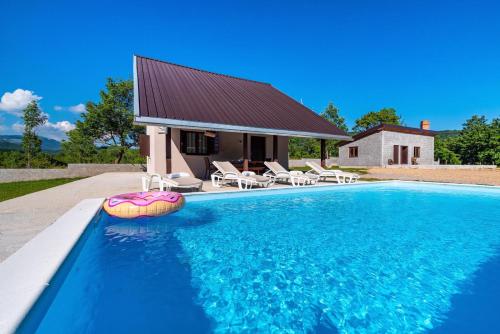 uma piscina em frente a uma casa em MONA em Gračac