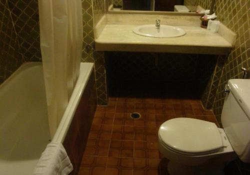 a bathroom with a toilet and a sink and a tub at Suda Palace in Bangkok