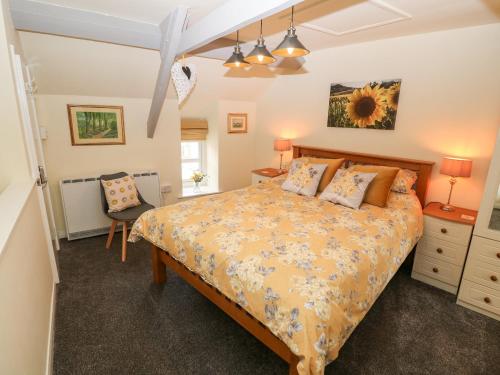 1 dormitorio con 1 cama y 1 silla en Garnedd, en Holyhead
