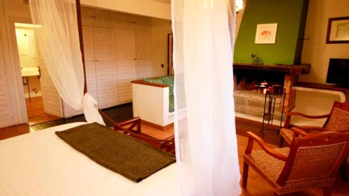 セルセディリャにあるCasona De Navalmedioのベッドルーム1室(ベッド1台付)、リビングルーム(暖炉付)