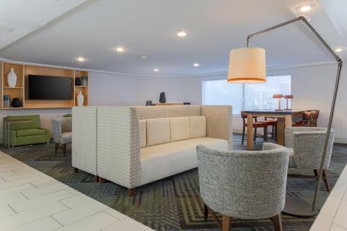 a living room with a couch and chairs and a table at Holiday Inn Express Milwaukee - West Medical Center by IHG in Wauwatosa