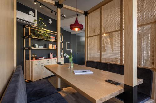 - une salle à manger avec une table en bois et un canapé dans l'établissement Oru Hub Hotel Tallinn - Handwritten Collection, à Tallinn