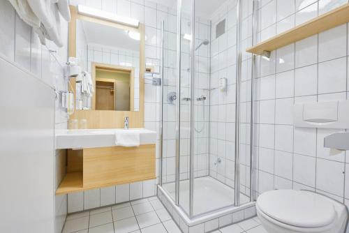 uma casa de banho com um chuveiro, um WC e um lavatório. em Hotel Restaurant Clemens-August em Ascheberg