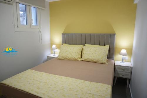 Casa Vista Spring في كارباثوس: غرفة نوم مع سرير مع مواقف ليلتين ومصباحين