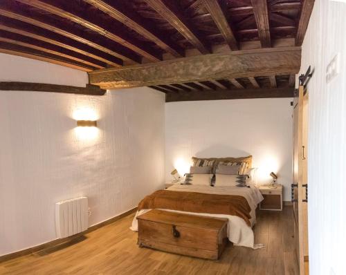 1 dormitorio con 1 cama grande y techo de madera en Alojamiento Turístico Alfonso y Catalina, en Cuenca