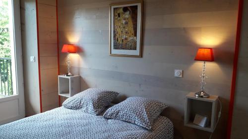 1 dormitorio con 1 cama con 2 lámparas en L'Atelier du Peintre, en Clairvaux-les-Lacs