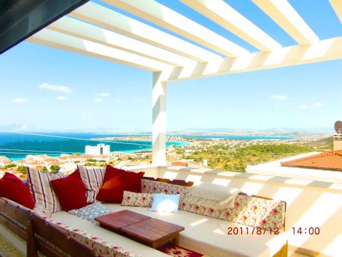 a couch on a balcony with a view of the ocean at Luxury Villa with amazing view, Cesme in Cesme