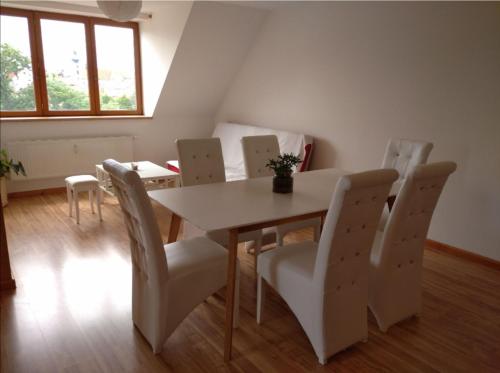 una sala da pranzo con tavolo e sedie bianchi di Riegrova a České Budějovice