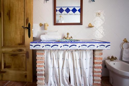 Los VillaresにあるApartamentos Casa Rural La Panderaのバスルーム(青と白のテーブル付)