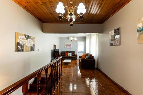 a hallway with a chandelier and a living room at Casa do Pescador SBMP-2 in Faial da Terra