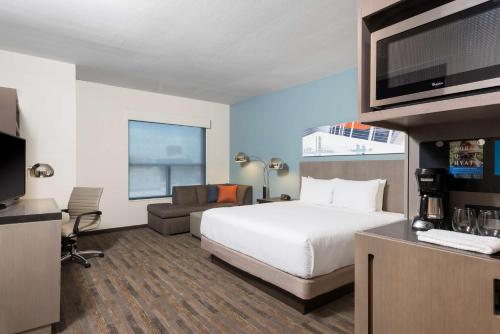 a hotel room with a bed and a flat screen tv at Hyatt House Austin/Downtown in Austin