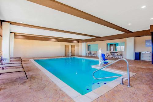 a large pool in a room with chairs and tables at La Quinta Inn & Suites by Wyndham Northlake Ft. Worth in Northlake
