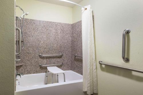 a bathroom with a shower and a tub and a sink at La Quinta by Wyndham Las Vegas Airport South in Las Vegas
