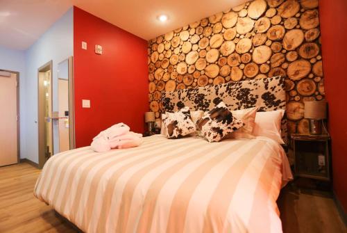 a bedroom with a large bed with logs on the wall at Days Inn by Wyndham Calgary North Balzac in Balzac