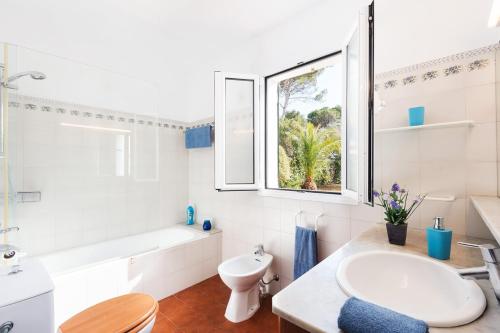 a bathroom with a sink and a tub and a window at Chalet tranquilo y acogedor a 50 metros de la playa in Cala Blanca