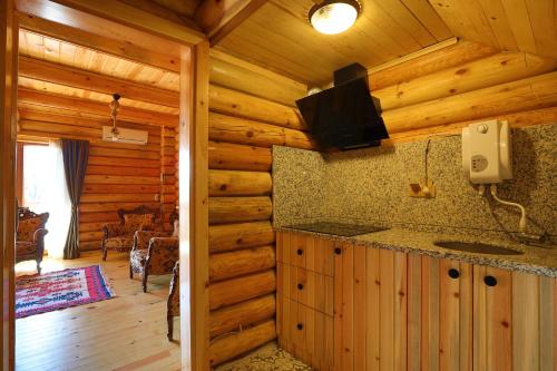 a kitchen in a log cabin with a tv on the wall at Kayi Apart Hotel in Bolu