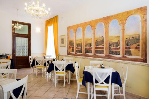 a restaurant with tables and chairs and a painting on the wall at B&B Locanda Il Tufo Rosa in Pitigliano
