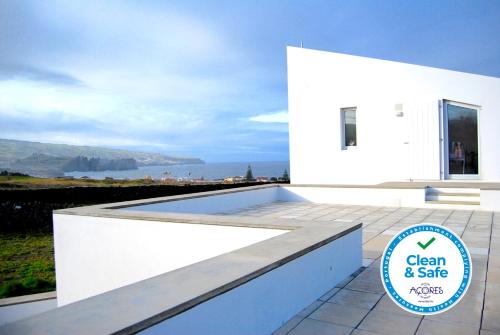 a white house with a sign that reads clean and safe at Quinta da Falesia - Casa Branca in Ponta Delgada