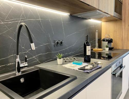 a kitchen with a sink and a bottle of wine at Maxim - Easy Home Booking in Nice