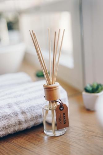a glass jar with bamboo sticks in it on a table at St. Nicholas lighthouse - island of Brač in Pučišća