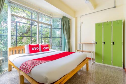 OYO 928 Leaf Hostel في شيانغ ماي: غرفة نوم مع سرير كبير وخزانات خضراء