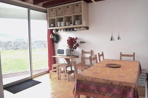 a kitchen and dining room with a table and chairs at Quinta da Falesia - Casa Branca in Ponta Delgada