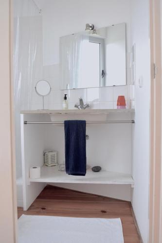 a bathroom with a sink and a blue towel at Quinta da Falesia - Casa Branca in Ponta Delgada