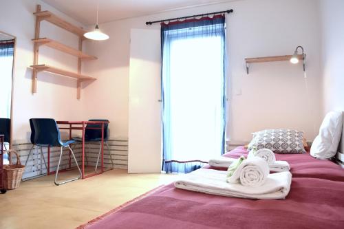 a bedroom with two beds and a chair in it at Quinta da Falesia - Casa Branca in Ponta Delgada