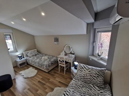 een slaapzaal met 2 bedden en een spiegel bij Apartman Božur **** in Satnica Ðakovačka