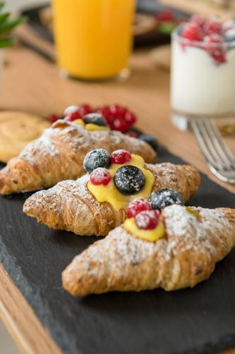 a black plate with pastries with fruit on it at Hotel San Marco in Cattolica