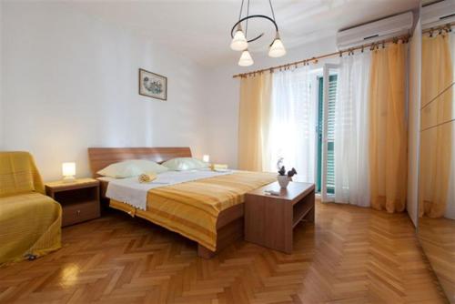 a bedroom with a large bed and a table at Apartments Marino Gojak in Makarska