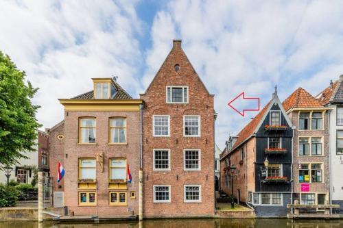 a building next to a canal with an arrow pointing up at Het Schaager Waapen in Alkmaar