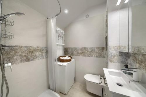 biała łazienka z toaletą i umywalką w obiekcie Bruno w mieście Krynica Zdrój