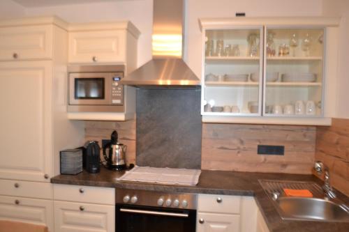 a kitchen with white cabinets and a stove top oven at Landhaus Marina in Werfenweng