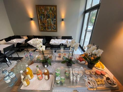 a table with food and drinks on it in a restaurant at Das Nikolai Hotel in Munich
