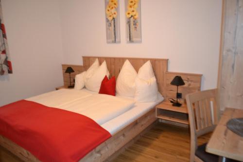 Schlafzimmer mit einem Bett mit weißen und roten Kissen in der Unterkunft Landhaus Marina in Werfenweng