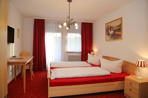 um quarto de hotel com duas camas e uma secretária em Parkhotel Waldlust em Häusern