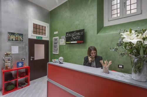 a woman sitting at a counter talking on a cell phone at Excellence Suite in Rome