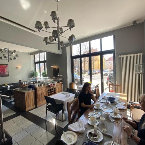 a group of people sitting at a table in a restaurant at Das Nikolai Hotel in Munich