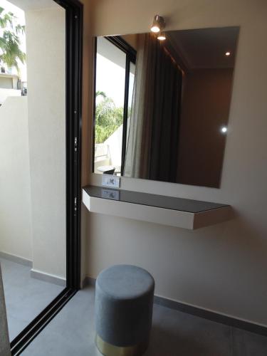 a mirror on a wall with a stool in a room at Paradise Hotel & Bar in Planos