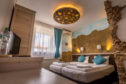a hotel room with two beds and a television at Tihiat Kut Complex in Kyustendil