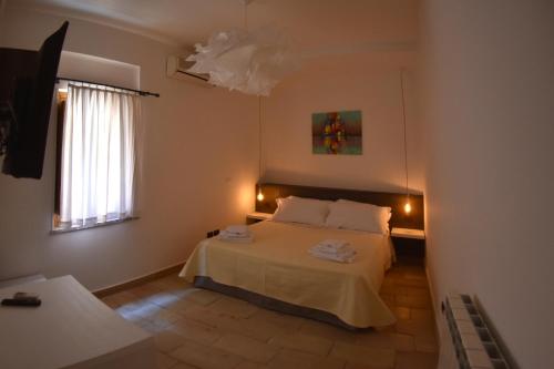 een slaapkamer met een wit bed en een raam bij Taormina al Bacio apartment in Taormina