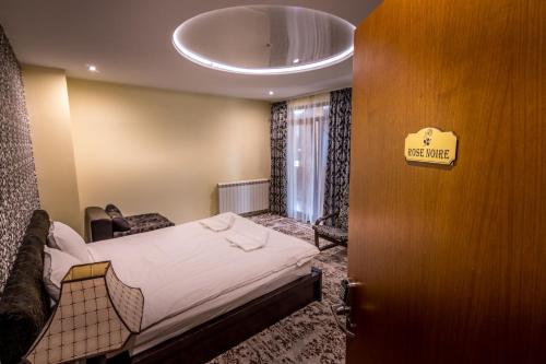 a room with a bed and a sign on a door at Tihiat Kut Complex in Kyustendil