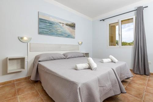 two beds in a white room with a window at Villa Novas Park in Son Parc